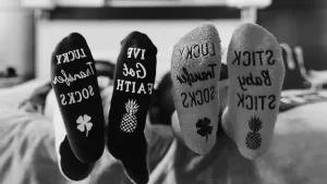 A picture showing the bottom of two surrogates feet. Their socks read "Stick Baby Stick" and "Lucky Transfer Socks"