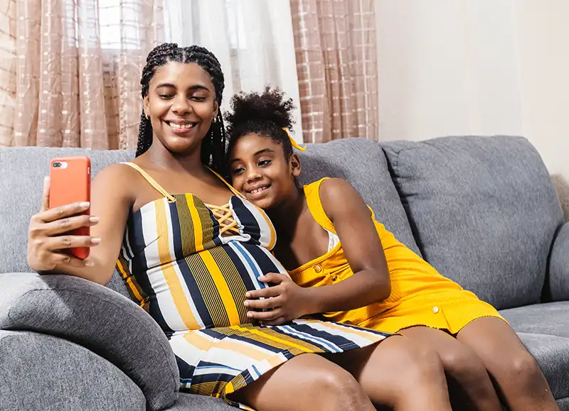 A pregnant woman and her daughter taking a selfie