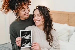 Intended parent couple looking at an ultrasound of their baby during a surrogate pregnancy